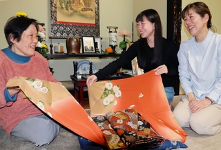 震災時に夫が持ち出した着物を手にする堀内トシコさん（左）。孫の森木美羽さん（中央）と娘の万寿美さんに思いをつなぐ＝和歌山県田辺市中辺路町