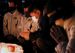 阪神・淡路大震災の発生時刻の１２時間前に黙とうを捧げる市民ら＝１６日午後５時４６分、神戸市中央区、東遊園地