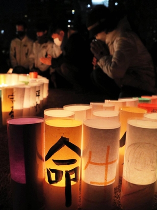 阪神・淡路大震災の発生時刻の１２時間前に黙とうを捧げる市民ら＝１６日午後５時４６分、神戸市中央区、東遊園地