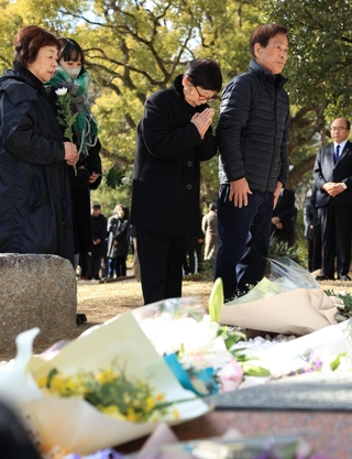 慰霊碑を前に花を手向け、手を合わせる遺族ら＝１７日午後０時５１分、神戸市灘区六甲台町、神戸大六甲台第１キャンパス