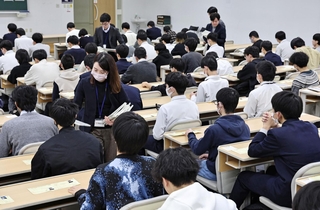 問題などが配布される中、試験開始を待つ受験生ら＝１８日午前、神戸市東灘区岡本８、甲南大（撮影・長嶺麻子）
