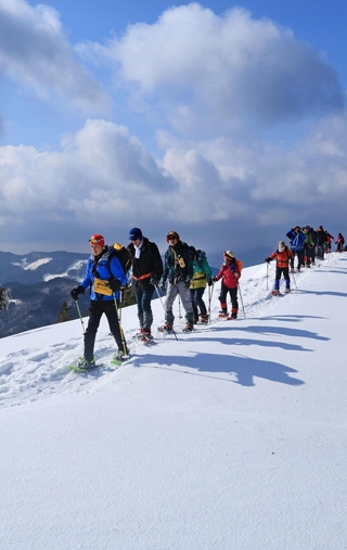 スノーシューを履いて雪山を進む登山会の参加者。厳寒期ならではの景色を満喫できる＝宍粟市千種町