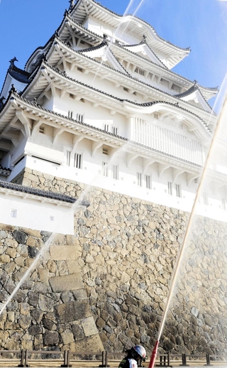 姫路城大天守に向けて放水する消防隊員＝26日午前、姫路市本町