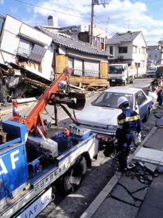 路肩で動けない車両の救援に当たるＪＡＦの職員＝１９９５年、撮影場所不明（ＪＡＦ提供）