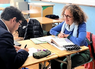 母語指導の時間に、現地の学校の教科書で学ぶ。先生との会話も弾む＝大阪府立長吉高校