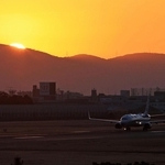 生駒山から顔をのぞかせる太陽。ちょうどＢ滑走路を最初の１機が走りだした＝１日午前７時１３分、伊丹市森本７、伊丹スカイパーク