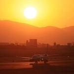 生駒山から昇る太陽を背にＢ滑走路を走る飛行機＝１日午前７時１７分、伊丹市森本７、伊丹スカイパーク