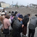 地震の発生時刻に合わせて黙祷する輪島市朝市組合の組合員ら＝１日午後４時１０分、石川県輪島市河井町（撮影・風斗雅博）