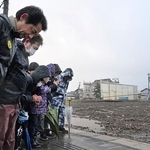 地震の発生時刻に合わせて黙祷する輪島市朝市組合の組合員ら＝１日午後４時１０分、石川県輪島市河井町（撮影・風斗雅博）
