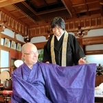 父が残した衣を着る冨永龍弘さん。母の明子さんも笑顔を見せる＝神戸市須磨区須磨寺町４