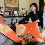 震災時に夫が持ち出した着物を手にする堀内トシコさん（左）。孫の森木美羽さん（中央）と娘の万寿美さんに思いをつなぐ＝和歌山県田辺市中辺路町