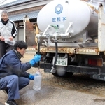 給水車から水をくみ住民に提供する市川町職員（手前）＝市川町鶴居、鶴居公民館
