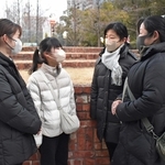 震災で亡くなった祖母、桑野寿美子さんの思い出話をする孫３人と、小学６年のひ孫（左から２人目）＝１７日午前７時、神戸市中央区加納町６、東遊園地