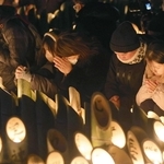 竹灯籠の前で手を合わせる人たち＝１７日午前５時４６分、神戸市中央区加納町６、東遊園地（撮影・辰巳直之）