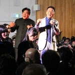 「上を向いて歩こう」を歌う佐渡裕さん（奥左）と五木ひろしさん（同右）＝１７日午後２時４４分、神戸市長田区若松町７、駒ケ林中学校