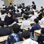 問題などが配布される中、試験開始を待つ受験生ら＝１８日午前、神戸市東灘区岡本８、甲南大（撮影・長嶺麻子）