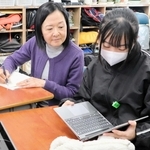 生徒と一緒にＮＩＥの授業に参加する小川洋子さん（左）＝西宮市立浜脇中学校