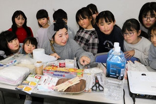 こども震災学校に参加した子どもたちに防災リュックの中身を解説する堀美恵子さん＝１日午後、神戸市中央区東川崎町１、神戸新聞社