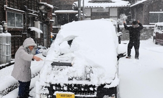 車に積もった雪を落とす住民ら＝４日午前、兵庫県香美町香住区下浜（撮影・長谷部崇）