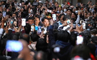 兵庫県知事選で当選確実となった斎藤元彦氏（中央）にスマートフォンを向ける人たち＝２０２４年１１月１７日、神戸市中央区