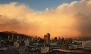 分厚い雲が立ちこめた夕方の神戸市街地。西日が差し、幻想的な光景に＝１７日夕、神戸市中央区東川崎町１から（撮影・笠原次郎）