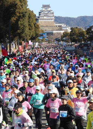 姫路城を背に一斉にスタートするランナー＝２３日午前、姫路市の大手前通り（撮影・辰巳直之）