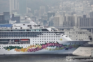 神戸港から出港する大型クルーズ船「ノルウェージャン・スカイ」。船体に花柄が描かれている＝28日午後、神戸市中央区（撮影・長嶺麻子）