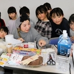 こども震災学校に参加した子どもたちに防災リュックの中身を解説する堀美恵子さん＝１日午後、神戸市中央区東川崎町１、神戸新聞社