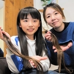 ヘアドネーションのため美容院で髪を切った松井依愛さん（左）。母の祐実さんも笑顔を見せた＝神戸市長田区