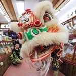 中国風の獅子舞が老舗あられ店で舞う。日中の文化が自然と融合する＝１日、神戸市中央区元町通２