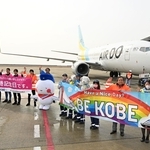 開港記念日を祝う横断幕を掲げて乗客らに手を振る航空会社の社員ら＝１６日午前、神戸空港（撮影・風斗雅博）