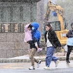 市街地に降り出した雪を避けるように通りを足早に歩く人たち＝１９日午後、神戸市中央区下山手通５（撮影・風斗雅博）
