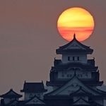 雲間からのぞく朝日を背に立つ姫路城＝２７日午前６時４７分、姫路市名古山町から
