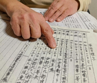 父の軍歴を指す石川豊子さん＝西宮市内