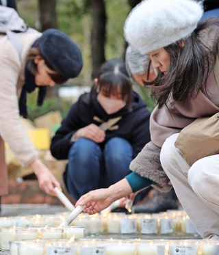 「３・１１　よりそう」とかたどったろうそくに火をともしていく参列者＝11日午後２時14分、神戸市中央区加納町６（撮影・丸山桃奈）