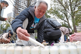 「３・１１　よりそう」とかたどったろうそくに火をともしていく参列者＝11日午後２時７分、神戸市中央区加納町６（撮影・丸山桃奈）
