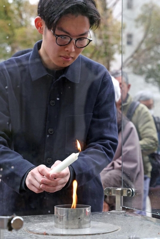「１・１７　希望の灯り」の火をとる参列者＝11日午後２時２分、神戸市中央区加納町６（撮影・丸山桃奈）