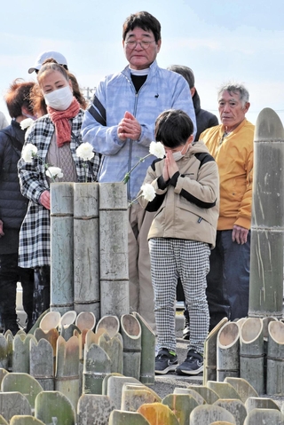 献花をして手を合わせる閖上地区の住民ら＝宮城県名取市閖上５