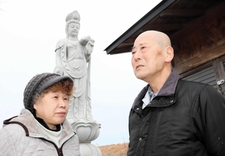 息子２人を思って建立した観音像の前で、１４年間を振り返る笹谷由夫さん（右）と妻美江子さん＝仙台市宮城野区蒲生