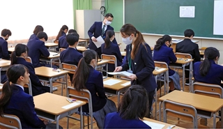 注意事項が配られ、試験開始に備える受験生たち＝１２日午前、神戸市東灘区向洋町中４、六甲アイランド高校