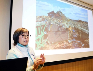 津波被害の写真を示しながら、自身の体験を語る安倍志摩子さん＝宮城県東松島市