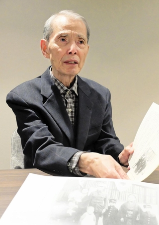 「空襲警報に備えて、服を着たまま寝る毎日だった」と、父親の出征時の家族写真を前に記憶を語る榎靖夫さん＝大阪府吹田市