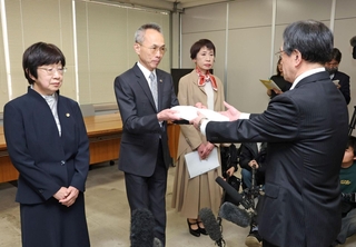 兵庫県の告発文書問題を調べる第三者調査委員会の藤本久俊委員長（左から２人目）から調査報告書を受け取る小畑由起夫県代表監査委員（右）＝１９日午後、神戸市中央区、兵庫県庁