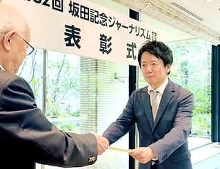 賞状を受け取る岸本達也論説委員（右）＝大阪市北区