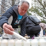 「３・１１　よりそう」とかたどったろうそくに火をともしていく参列者＝11日午後２時７分、神戸市中央区加納町６（撮影・丸山桃奈）