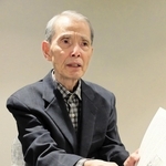 「空襲警報に備えて、服を着たまま寝る毎日だった」と、父親の出征時の家族写真を前に記憶を語る榎靖夫さん＝大阪府吹田市