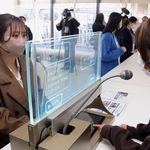 会話を自動翻訳するディスプレー型機器を使い、多言語で会場案内を実演するゲストサービスアテンダント＝大阪市此花区
