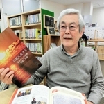 支援を続けた宮城県気仙沼市・只越地区の復興記念誌を手に語る野崎隆一さん＝神戸市中央区