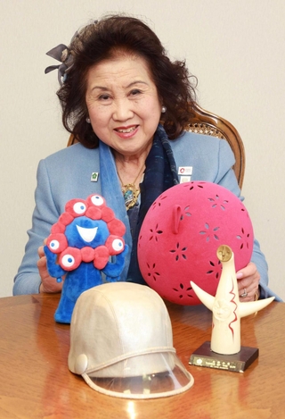 １９７０年の大阪万博で手がけた帽子（手前）や万博のタイムカプセルに入れた帽子のレプリカを手にする渡邊百合社長＝神戸市中央区北長狭通２、マキシン本社（撮影・笠原次郎）