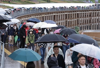 奥まで続く傘を持った人の列＝１３日午後、大阪市此花区（撮影・丸山桃奈）